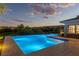 Backyard swimming pool with underwater lighting, baja step, and beautiful desert views at twilight at 11473 Glowing Sunset Ln, Las Vegas, NV 89135