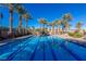 Inviting swimming pool with clear blue water and palm trees creating a relaxing oasis at 11473 Glowing Sunset Ln, Las Vegas, NV 89135