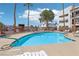 Inviting community pool surrounded by palm trees and lounge chairs, perfect for relaxation and recreation at 1381 E University Ave # 301, Las Vegas, NV 89119