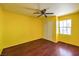 Vibrant yellow bedroom with hardwood flooring, a window, and a ceiling fan at 2180 Maple Shade St, Henderson, NV 89002