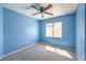Bright blue bedroom with a window, ceiling fan, and neutral carpet at 2180 Maple Shade St, Henderson, NV 89002