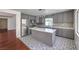 The kitchen has gray cabinets, stainless steel appliances, an island, and decorative tile flooring at 2180 Maple Shade St, Henderson, NV 89002