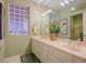 Bright bathroom with a double sink vanity, a glass block window, and neutral decor at 2720 Spalding Dr, Las Vegas, NV 89134