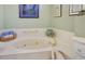 Close-up of relaxing soaking tub with brass faucet, tiled surround, and green wall at 2720 Spalding Dr, Las Vegas, NV 89134