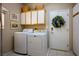 Bright laundry room with overhead cabinets and white appliances provides great storage at 2720 Spalding Dr, Las Vegas, NV 89134