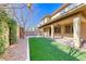 Inviting backyard featuring artificial grass, brick patio, and a covered area perfect for outdoor entertaining at 3049 Echoed Rondel Ln, Henderson, NV 89044