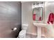 Powder room with modern vanity, pedestal sink and decorative mirror at 3049 Echoed Rondel Ln, Henderson, NV 89044