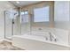 Bright bathroom featuring a soaking tub and glass-enclosed shower with natural light at 3049 Echoed Rondel Ln, Henderson, NV 89044