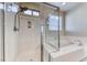 Bright bathroom featuring a soaking tub and glass-enclosed shower at 3049 Echoed Rondel Ln, Henderson, NV 89044
