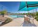 A serene community pool area with ample seating, shaded spots, and beautiful landscaping at 3049 Echoed Rondel Ln, Henderson, NV 89044