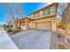 Inviting two-story home with a brick-accented porch, neutral color scheme, and a paved driveway at 3049 Echoed Rondel Ln, Henderson, NV 89044