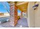 Close-up of the covered front porch with brick columns and a tiled floor at 3049 Echoed Rondel Ln, Henderson, NV 89044