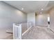 Upstairs hallway featuring neutral colored walls, white railing, and carpeted floors at 3049 Echoed Rondel Ln, Henderson, NV 89044