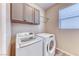 Laundry room featuring modern washer and dryer units and cabinet storage at 3049 Echoed Rondel Ln, Henderson, NV 89044