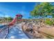 A charming community playground including a ramp and an orange slide on a sunny day at 3049 Echoed Rondel Ln, Henderson, NV 89044