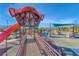Community playground featuring a ramp leading to a tower with an orange slide under a clear sky at 3049 Echoed Rondel Ln, Henderson, NV 89044