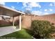 Covered back patio area with artificial turf, brick wall, and a mature bush at 344 Tuscany Cir, Mesquite, NV 89027