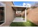 Covered back patio area with artificial turf and a sliding glass door into the home at 344 Tuscany Cir, Mesquite, NV 89027