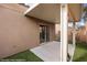 Covered back patio area with artificial turf and a sliding glass door into the home at 344 Tuscany Cir, Mesquite, NV 89027