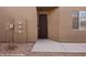 Exterior view of a front entrance with brown door, beige stucco walls, and a small window at 344 Tuscany Cir, Mesquite, NV 89027