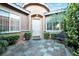 Inviting front entrance with a tiled patio, a cozy bench, and manicured greenery at 3615 Hardwick Hall Way, Las Vegas, NV 89135
