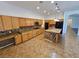 Open kitchen with wooden cabinetry, granite countertops, kitchen island and an open floorplan at 3615 Hardwick Hall Way, Las Vegas, NV 89135