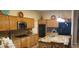 Well-lit kitchen with wooden cabinetry, granite countertops, stainless steel appliances, and island at 3615 Hardwick Hall Way, Las Vegas, NV 89135