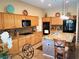 Bright kitchen with wood cabinets, granite counters, stainless appliances, and island with seating at 3615 Hardwick Hall Way, Las Vegas, NV 89135