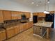 Bright kitchen featuring wooden cabinets, granite countertops, stainless steel appliances, and island at 3615 Hardwick Hall Way, Las Vegas, NV 89135