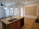 Kitchen island with granite countertop, stainless steel sink, and adjacent dining area with bright windows at 3615 Hardwick Hall Way, Las Vegas, NV 89135