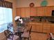 Bright eat-in kitchen featuring a glass dining table with oak cabinets and granite countertops at 3615 Hardwick Hall Way, Las Vegas, NV 89135