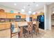 Well-lit kitchen with wooden cabinets, granite countertops, an island with bar stools, and stainless-steel appliances at 3615 Hardwick Hall Way, Las Vegas, NV 89135