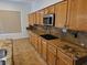 Close-up of kitchen with wooden cabinets, granite countertops, and stainless steel microwave at 3615 Hardwick Hall Way, Las Vegas, NV 89135