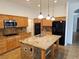 Bright kitchen features wooden cabinets, granite countertops, stainless steel appliances, and an island with pendant lighting at 3615 Hardwick Hall Way, Las Vegas, NV 89135