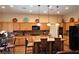 Warm kitchen with wooden cabinets, granite counters, stainless appliances, and an island with seating at 3615 Hardwick Hall Way, Las Vegas, NV 89135