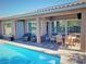 Covered patio next to the pool, furnished with a dining area and comfortable seating at 3615 Hardwick Hall Way, Las Vegas, NV 89135