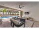 Relaxing covered patio area with modern seating, a ceiling fan, and views of the sparkling pool at 3731 Caesars Cir, Las Vegas, NV 89120