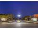 Verde Valle community entrance with lush trees, a central median, and well-maintained landscaping at night at 3731 Caesars Cir, Las Vegas, NV 89120