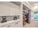 Bright pantry with white cabinets, subway tile backsplash, stainless steel refrigerator and wire rack shelving at 3731 Caesars Cir, Las Vegas, NV 89120
