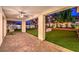 Inviting covered patio offers a cool retreat, overlooking a backyard with giant chess set and string lights at 3731 Caesars Cir, Las Vegas, NV 89120