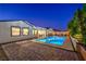 Captivating backyard pool with a spa and illuminated water, complemented by a cozy outdoor dining space at 3731 Caesars Cir, Las Vegas, NV 89120