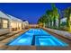 Inviting backyard pool with a spa and illuminated water, framed by lush greenery and landscape lighting at 3731 Caesars Cir, Las Vegas, NV 89120