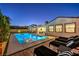 Stunning backyard pool with illuminated water, lounge chairs and outdoor dining area for elegant relaxation at 3731 Caesars Cir, Las Vegas, NV 89120
