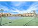 View of a tennis court surrounded by fenced condos, street lights, and sparse landscaping under a sunny blue sky at 3790 Shirebrook Dr # 167, Las Vegas, NV 89115