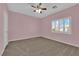 Bright bedroom features plush carpet, ceiling fan, and sun-filled window at 4063 Lower Saxon Ave, North Las Vegas, NV 89085