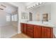 Dual sink bathroom vanity with cherry wood cabinets, plenty of light, and ample counter space at 4740 Killington St, Las Vegas, NV 89129