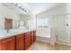 Bright bathroom with a double sink vanity, separate bathtub, and tiled shower at 4740 Killington St, Las Vegas, NV 89129