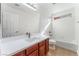 Bright bathroom featuring a single sink vanity with wood cabinets and tub with shower at 4740 Killington St, Las Vegas, NV 89129