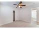Bedroom with neutral carpet, ceiling fan, and a view into the bathroom at 4740 Killington St, Las Vegas, NV 89129