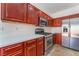 Well-equipped kitchen with stainless steel appliances and cherry wood cabinetry at 4740 Killington St, Las Vegas, NV 89129